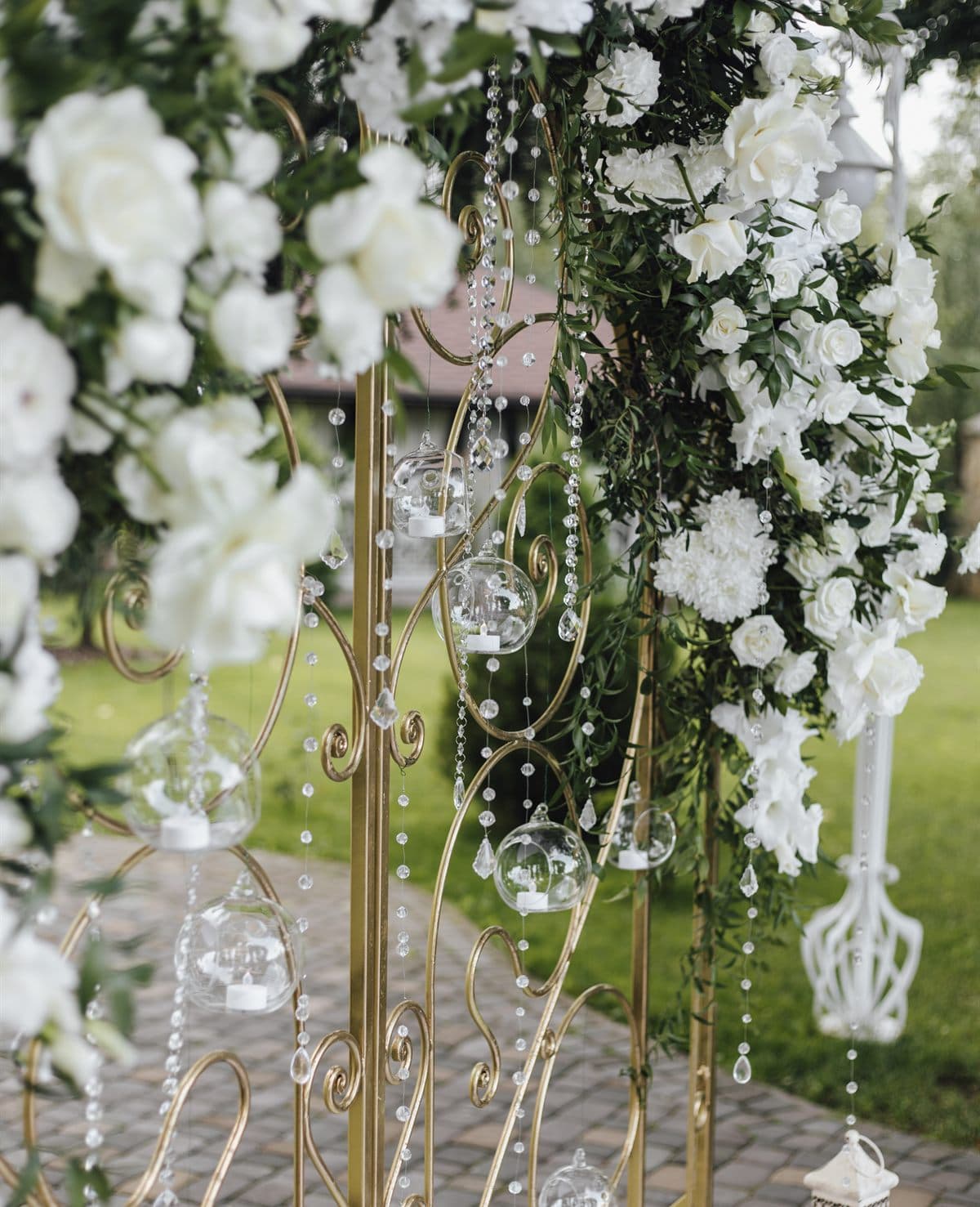 Arco floral con rosas blancas y farolillos de cristal