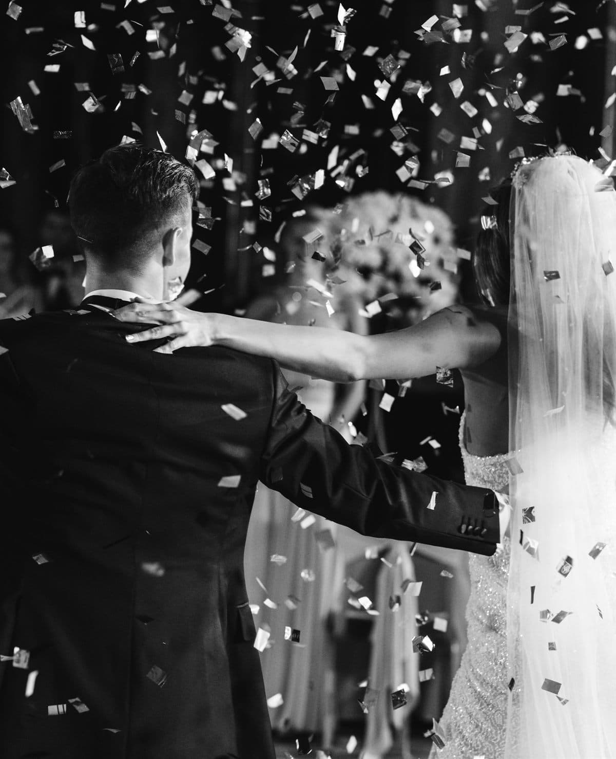 Novios celebrando entre confeti el día de su boda