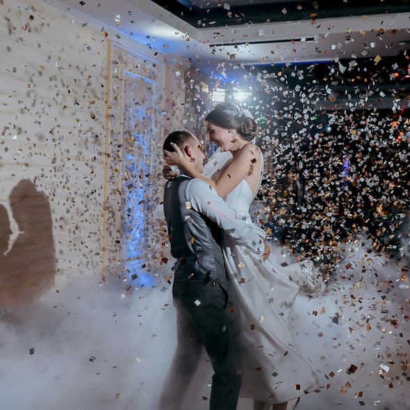 Novios bailando entre confeti dorado